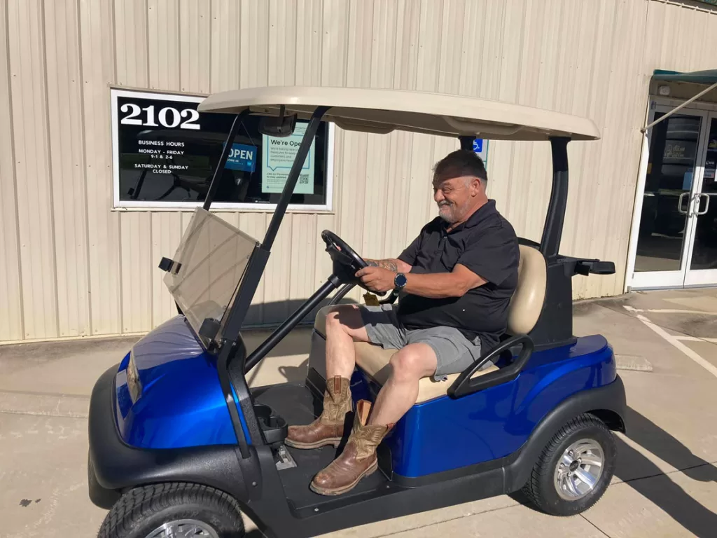 happy golf cart customer on blue golf car