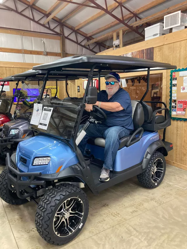 man on golf cart inside Allison Golf Cars